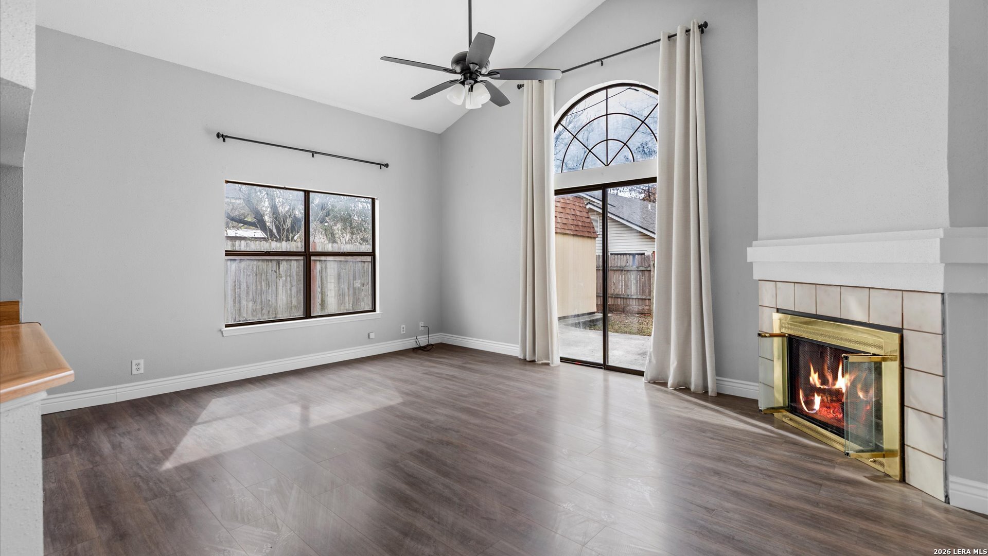 9847 Spring Harvest San Antonio, TX 78254 - Photo 12 of 27 an empty room with wooden floor fireplace and windows