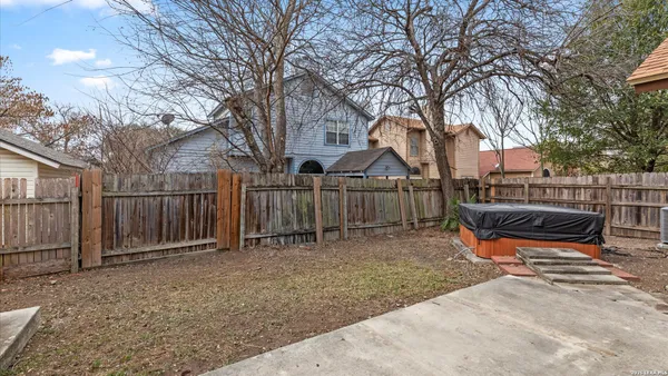 a view of a house with backyard and trees