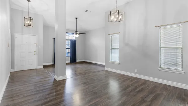 a view of empty room with wooden floor and ceiling fan