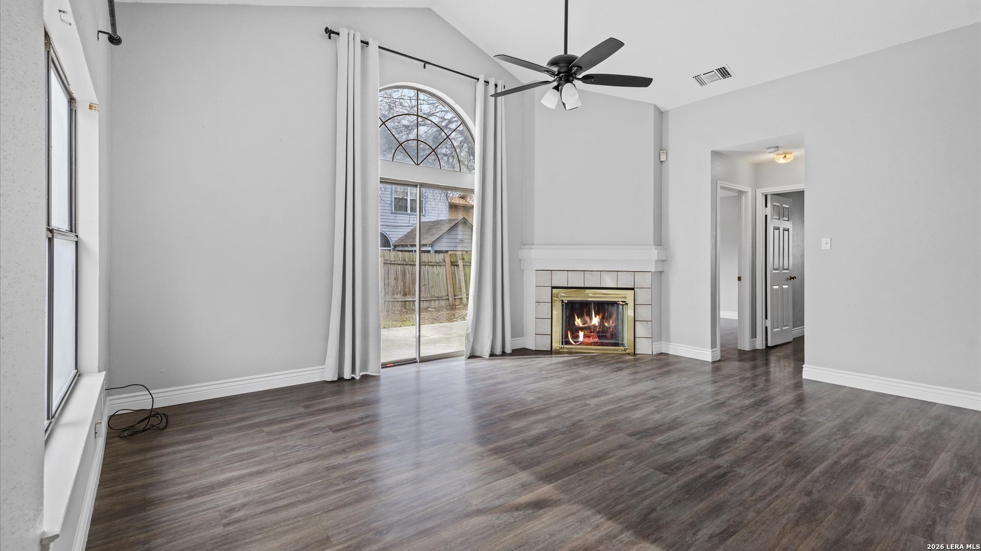9847 Spring Harvest San Antonio, TX 78254 - Photo 10 of 27 an empty room with wooden floor fireplace and windows