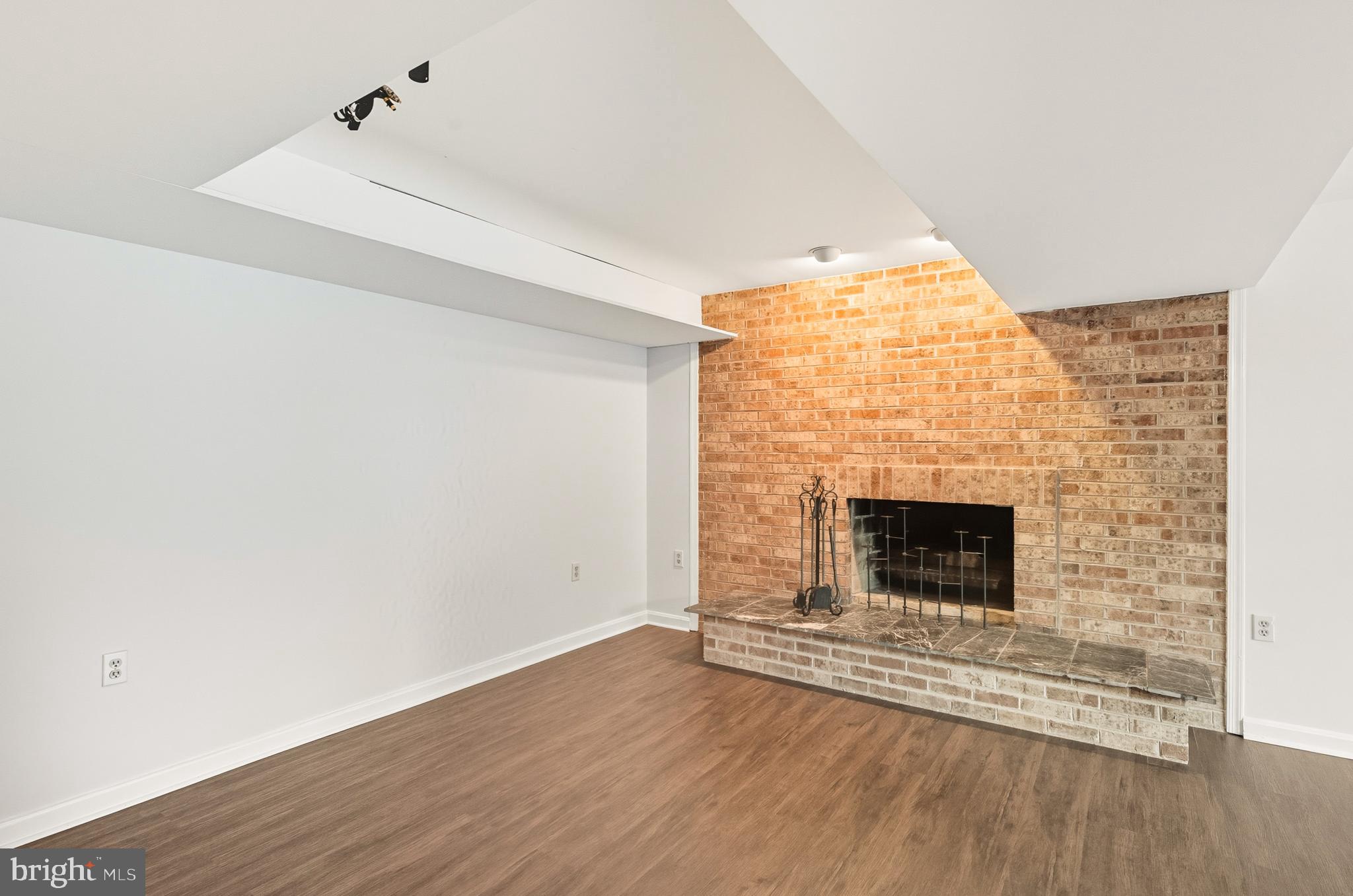 2352 Cedar Lane Vienna, VA 22182 - Photo 42 of 59 a view of an empty room with wooden floor and a fireplace