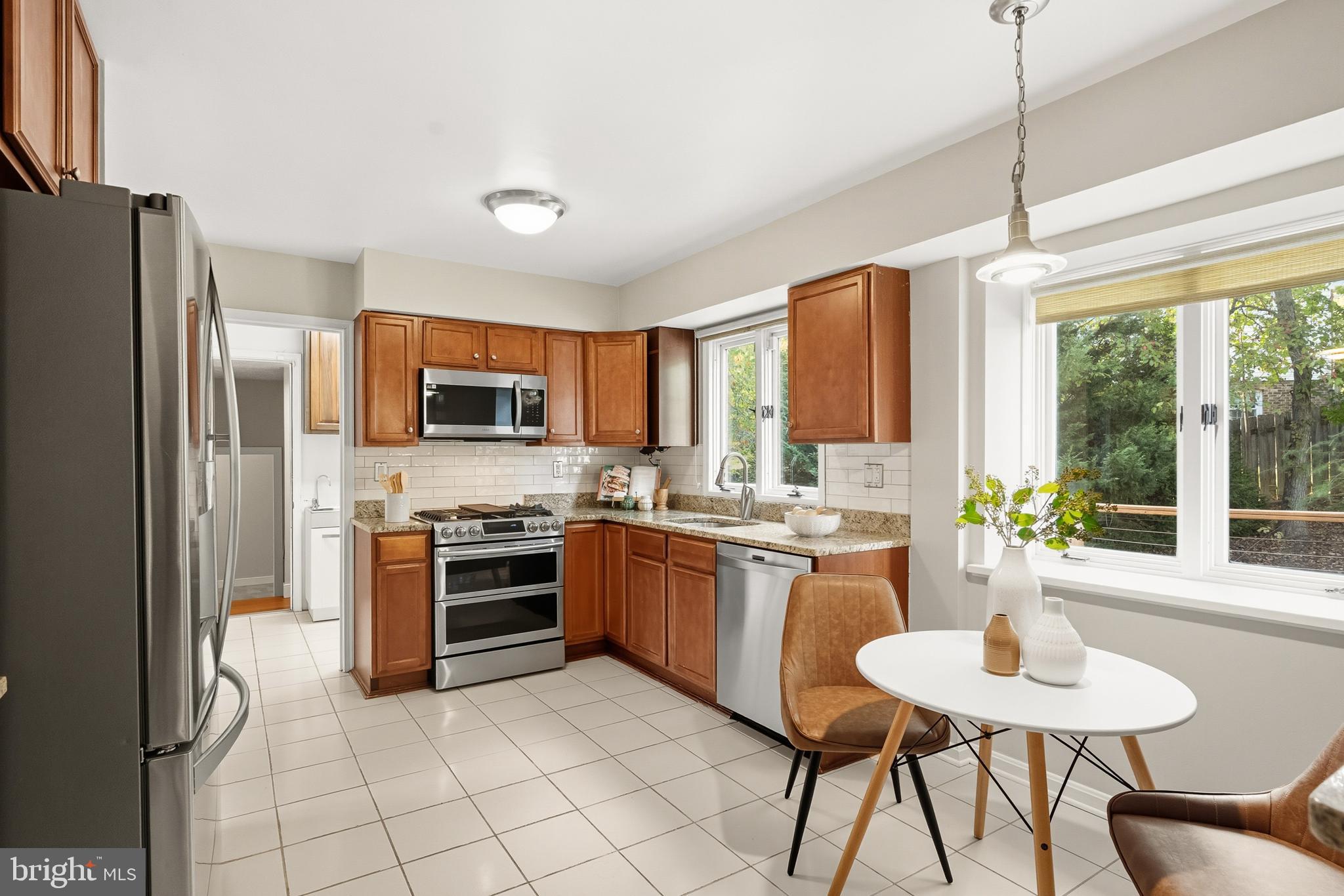 2352 Cedar Lane Vienna, VA 22182 - Photo 10 of 59 a kitchen with stainless steel appliances granite countertop a stove top oven a sink dishwasher a dining table and chairs with wooden floor