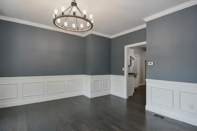 a kitchen with white cabinets and wooden floor