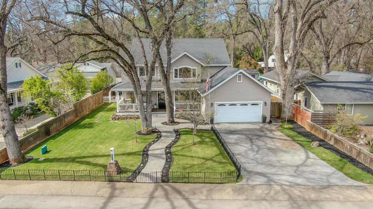 a view of house with a yard and potted plants