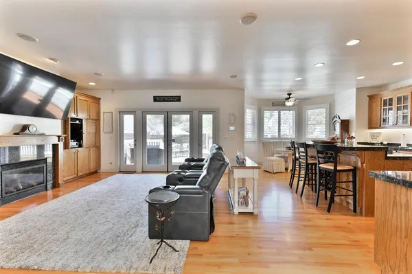 a kitchen with stainless steel appliances kitchen island granite countertop a dining table chairs and refrigerator