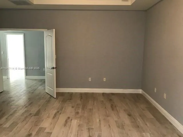 a view of an empty room with wooden floor