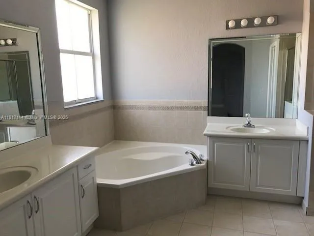 a bathroom with a sink vanity tub and a mirror