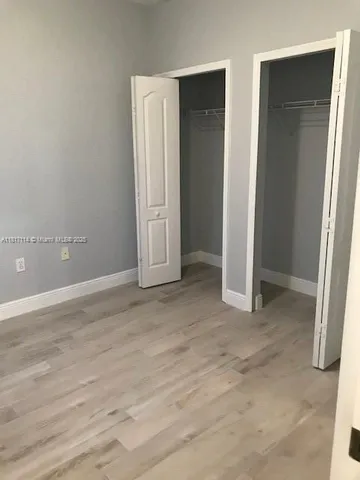 an empty room with closet and mirror