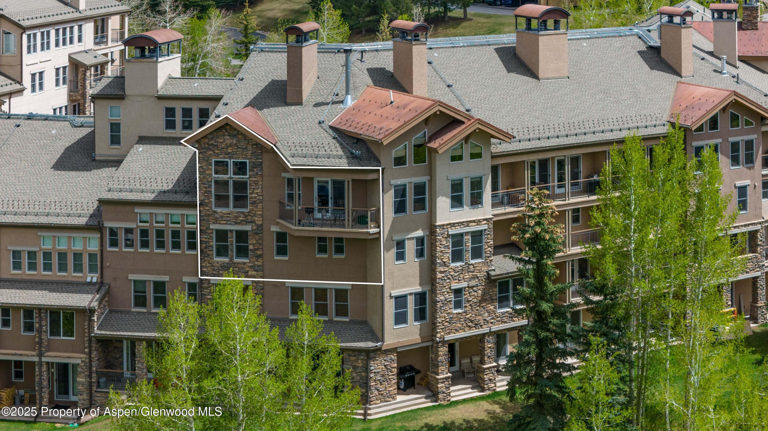 425 Wood Road, Unit 48 Snowmass Village, CO 81615 - Photo 3 of 41 a front view of a residential apartment building with a yard