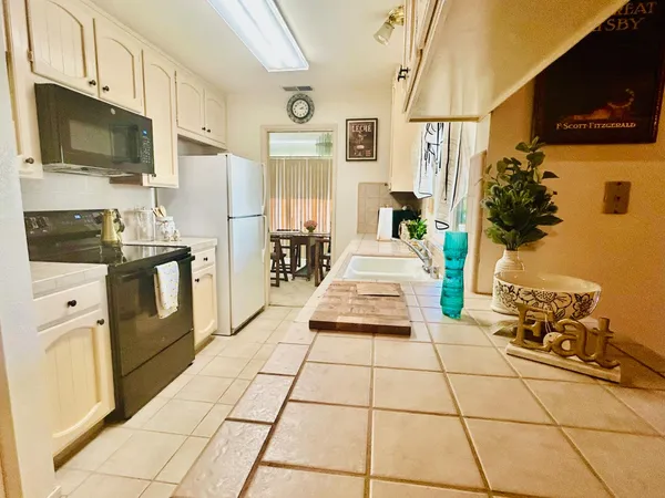 a living room with stainless steel appliances a stove a sink and a refrigerator