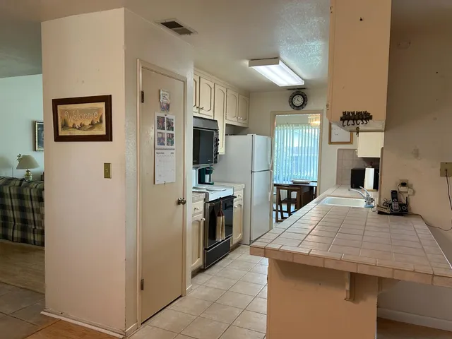 a kitchen with stainless steel appliances a stove refrigerator and cabinets