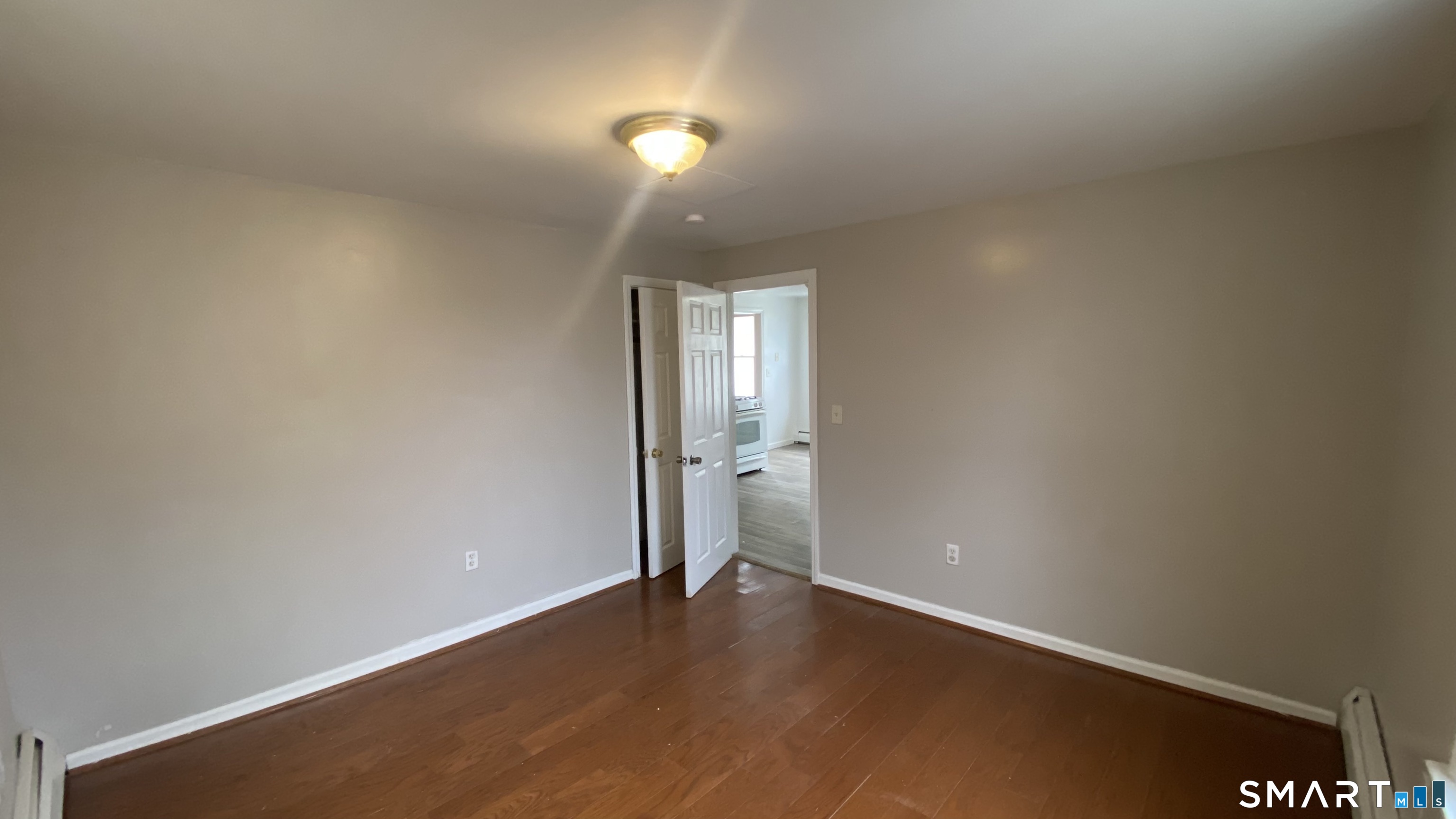 82 James Street, Unit 2 Torrington, CT 06790 - Photo 17 of 23 an empty room with wooden floor and windows