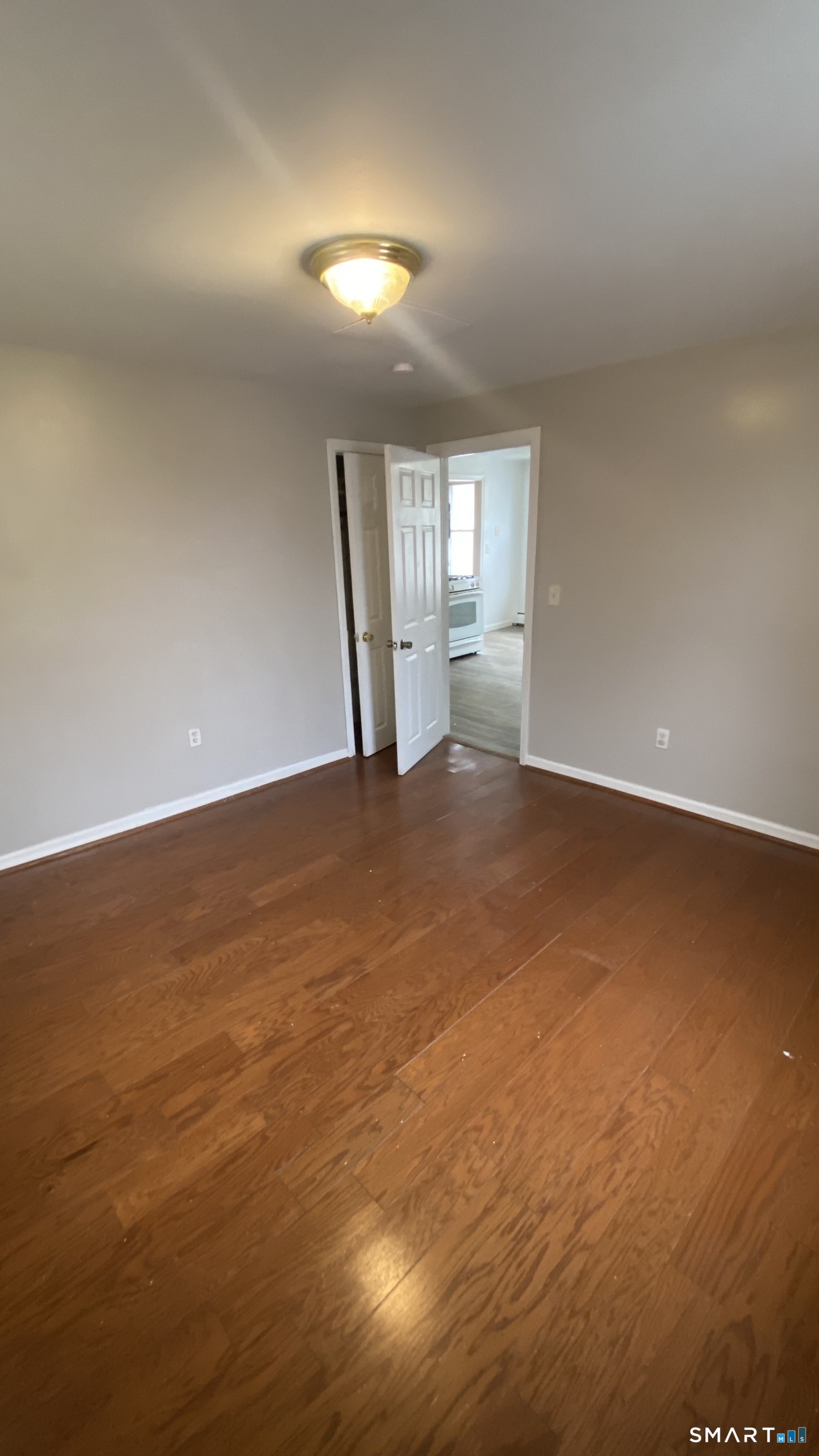 82 James Street, Unit 2 Torrington, CT 06790 - Photo 18 of 23 an empty room with wooden floor and windows in it