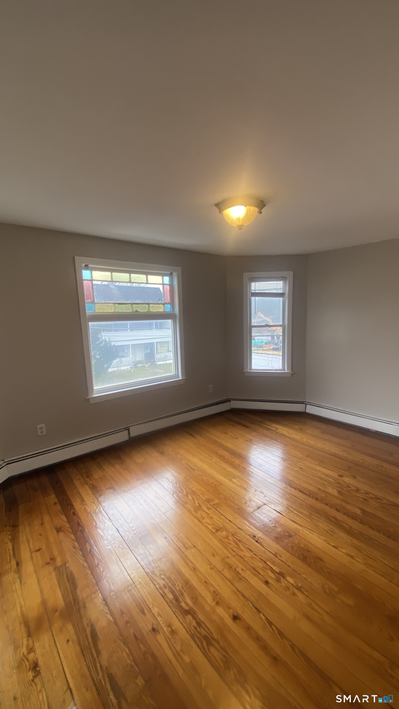 82 James Street, Unit 2 Torrington, CT 06790 - Photo 5 of 23 an empty room with wooden floor and windows