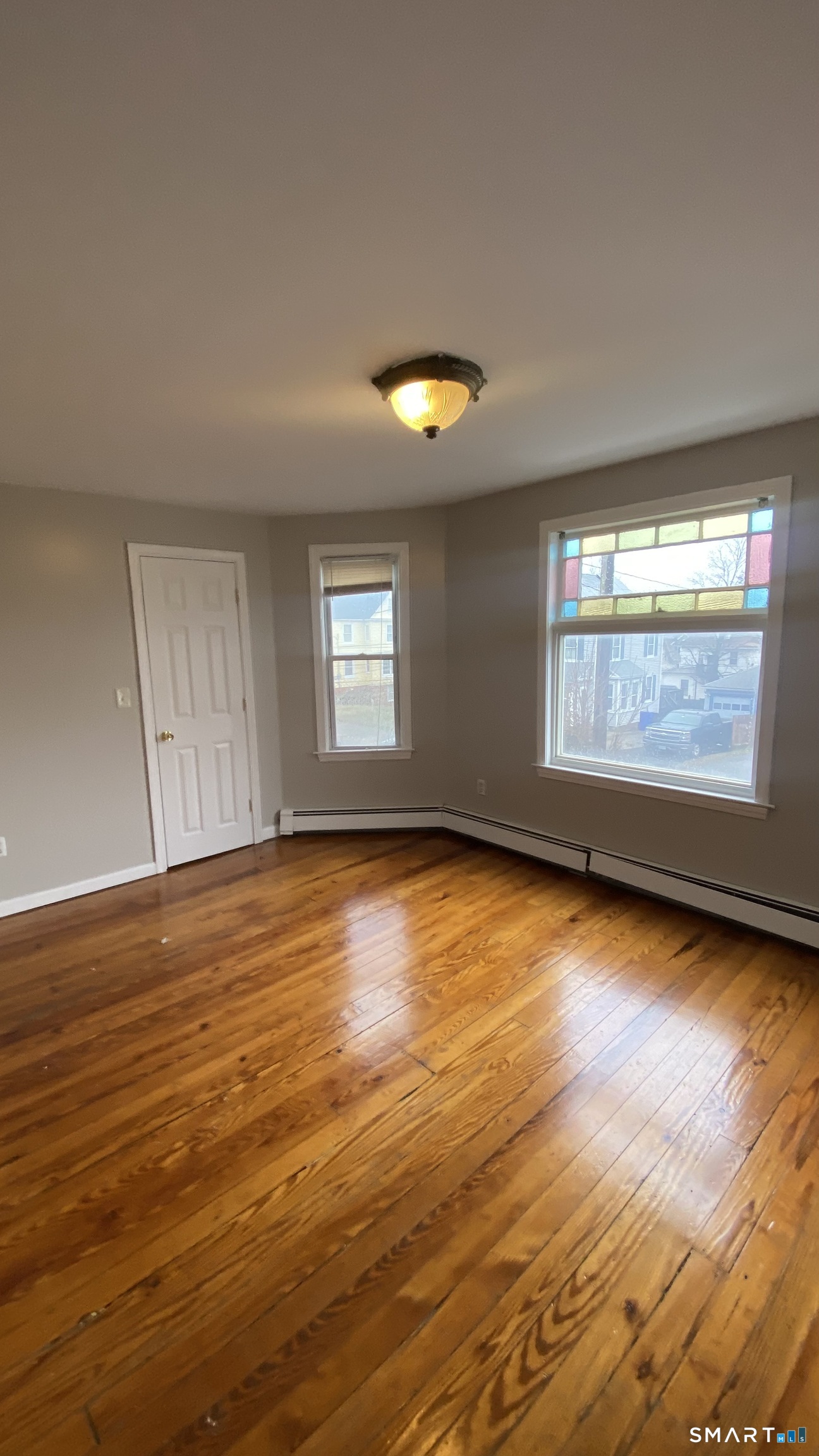 82 James Street, Unit 2 Torrington, CT 06790 - Photo 6 of 23 an empty room with wooden floor and windows