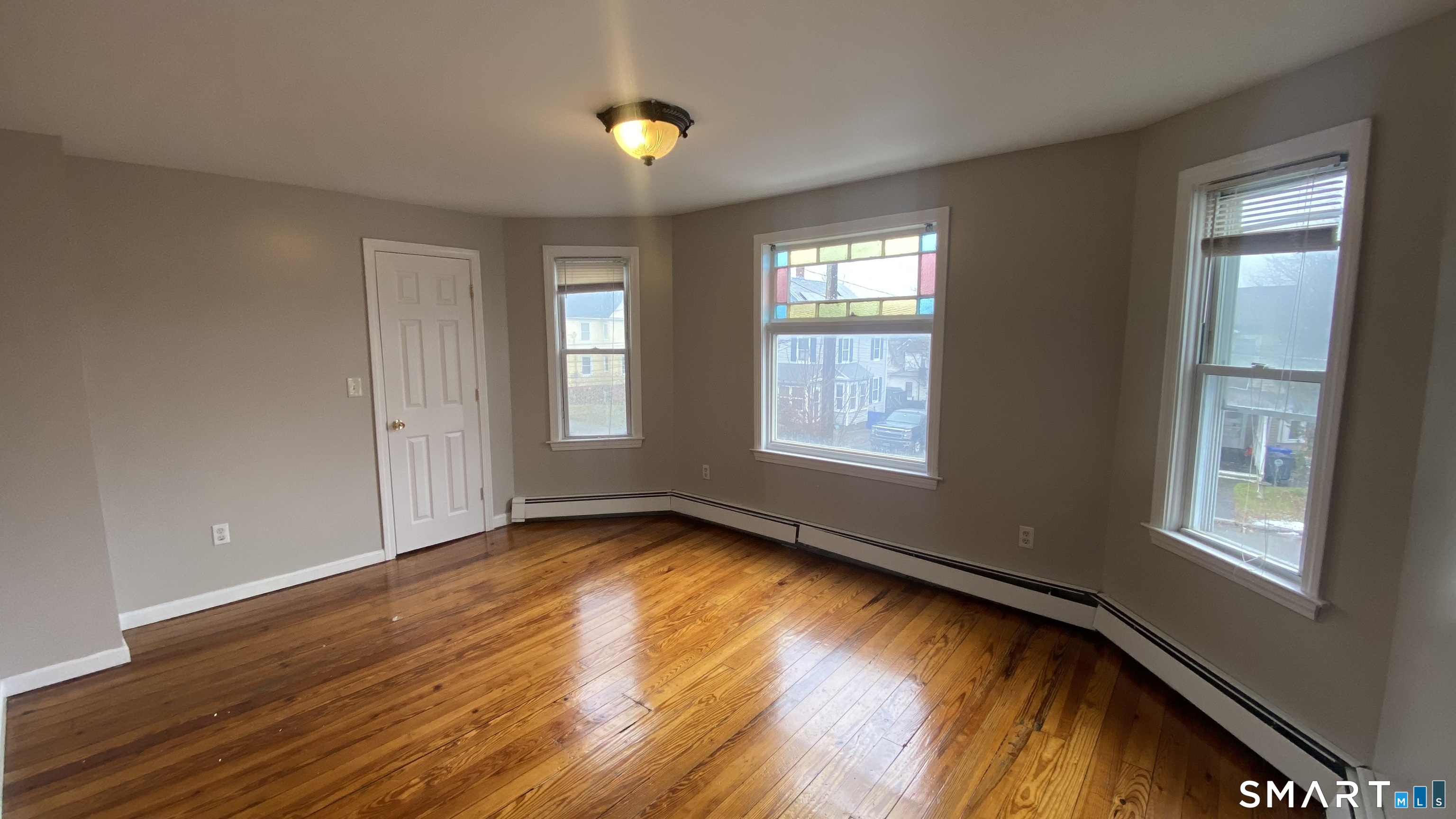 82 James Street, Unit 2 Torrington, CT 06790 - Photo 7 of 23 a view of an empty room with window and wooden floor