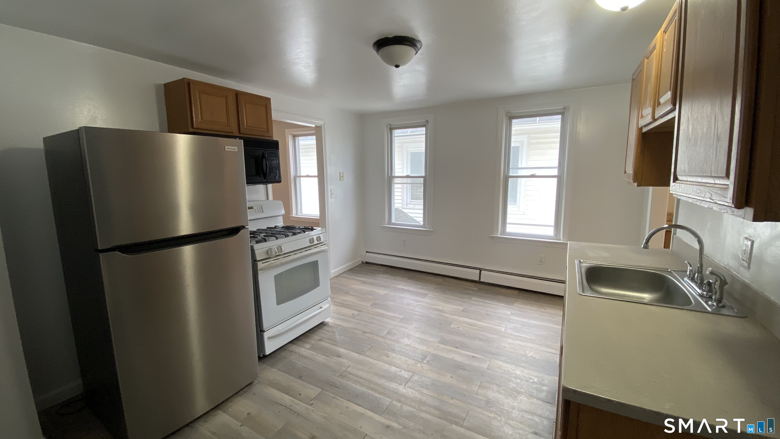 82 James Street, Unit 2 Torrington, CT 06790 - Photo 10 of 23 a kitchen with stainless steel appliances granite countertop a refrigerator a sink a stove and a refrigerator with wooden floor