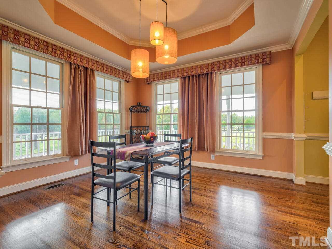 2302 Tilley Farm Road Rougemont, NC 27572 - Photo 8 of 30 a dining room with wooden floor a chandelier a glass table and chairs