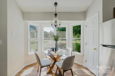 a dining room with furniture a chandelier and window