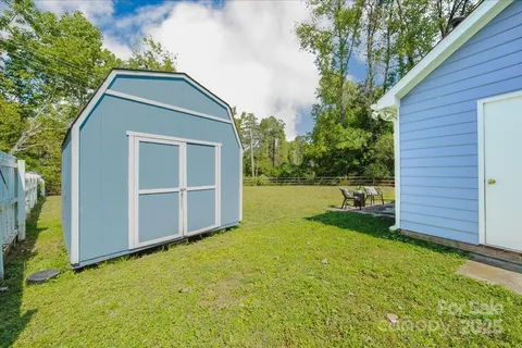 a backyard of a house with plants and wooden fence
