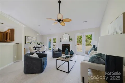 a living room with furniture a fireplace and a chandelier