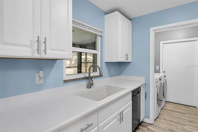 a kitchen with stainless steel appliances granite countertop a sink and a microwave with wooden cabinets