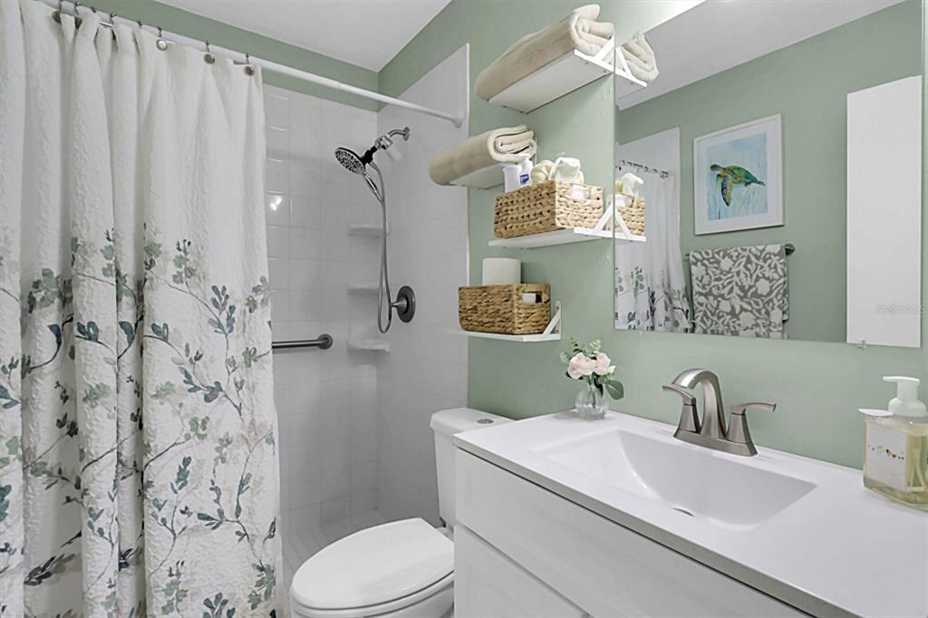 3409 Plaza Avenue Spring Hill, FL 34608 - Photo 15 of 41 a bathroom with a sink a toilet and shower curtain