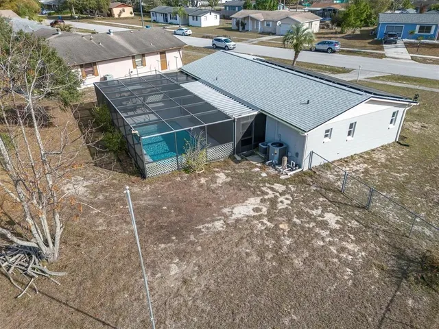 an aerial view of a house with a yard wooden table and chairs