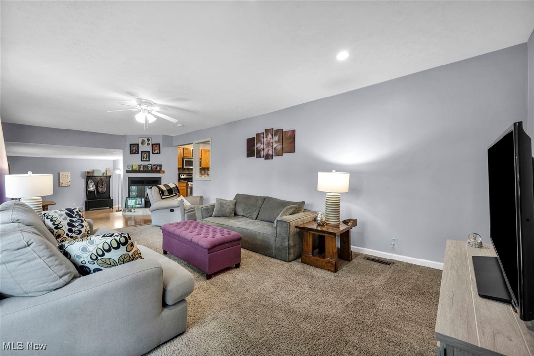 3954 Homestead Road Ravenna, OH 44266 - Photo 15 of 46 Carpeted living room featuring a ceiling fan and a fireplace