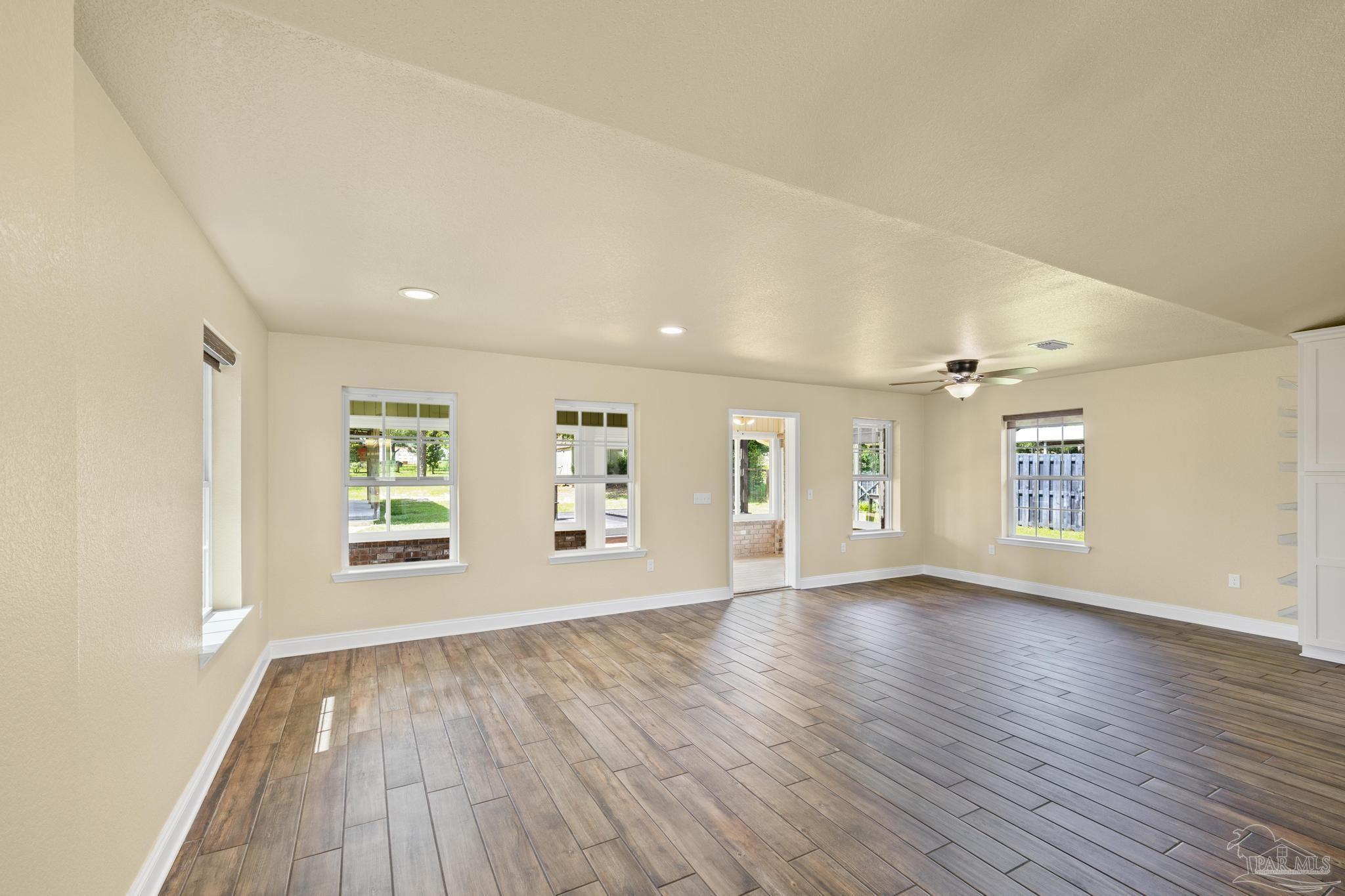 8114 Silver Maple Drive Milton, FL 32583 - Photo 5 of 32 an empty room with wooden floor and windows
