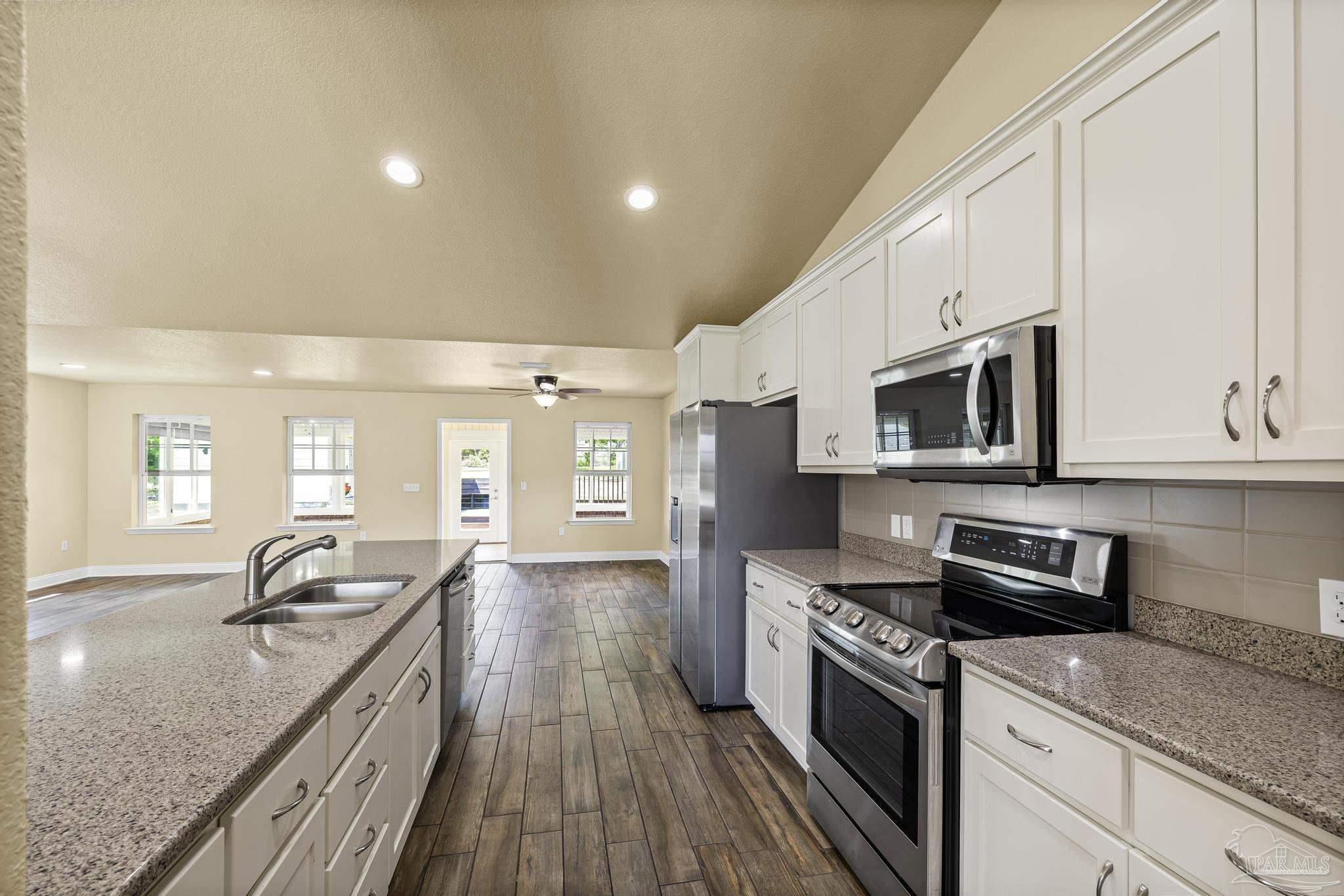 8114 Silver Maple Drive Milton, FL 32583 - Photo 8 of 32 a kitchen with stainless steel appliances granite countertop a sink stove and microwave