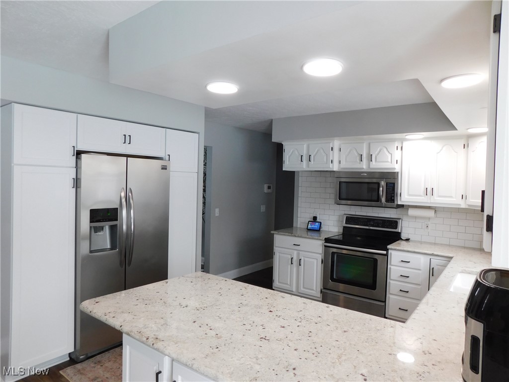 3273 Anglo Circle Northwest Canton, OH 44708 - Photo 5 of 33 Open kitchen featuring white cabinetry, appliances with stainless steel finishes, and kitchen peninsula