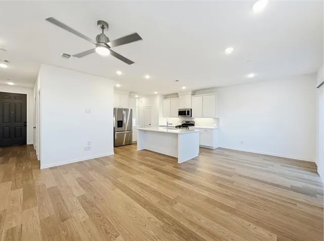 a view of kitchen with stainless steel appliances kitchen island a refrigerator and a sink