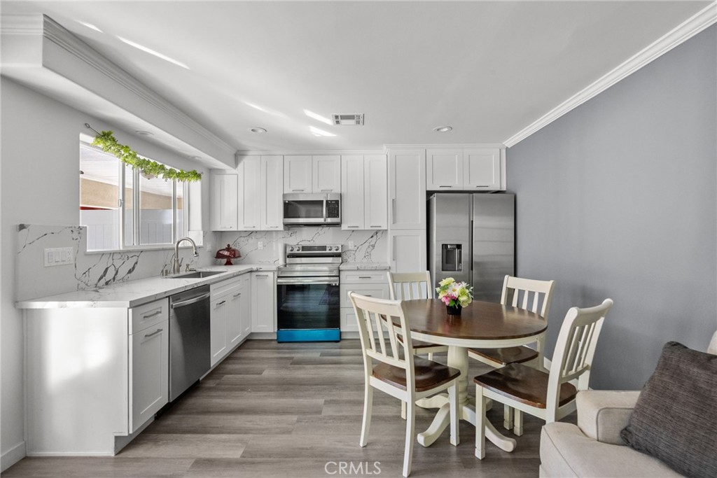 7839 Lena Avenue West Hills, CA 91304 - Photo 26 of 65 a kitchen with stainless steel appliances kitchen island granite countertop a dining table chairs and granite counter tops