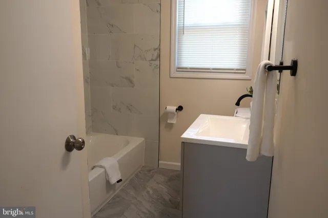 a bathroom with a tub sink and window