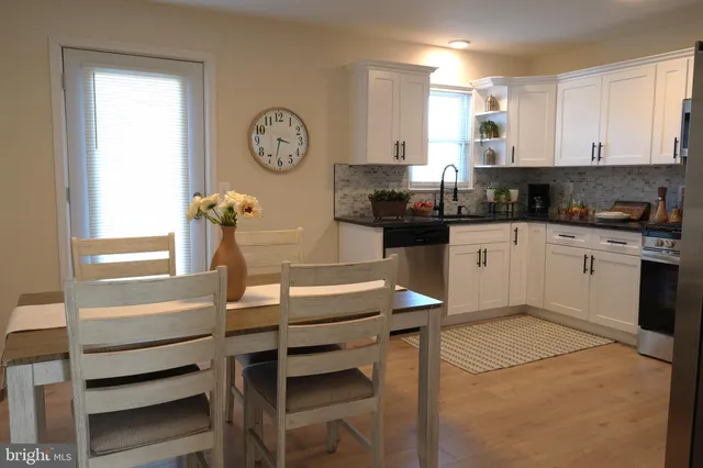 a kitchen with granite countertop white cabinets and stainless steel appliances