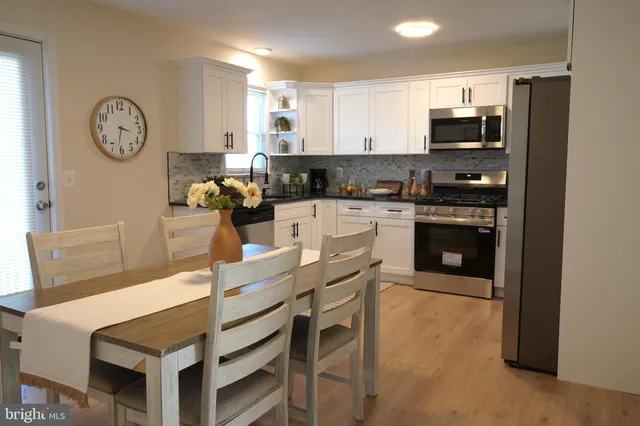 a kitchen with a table chairs microwave and cabinets