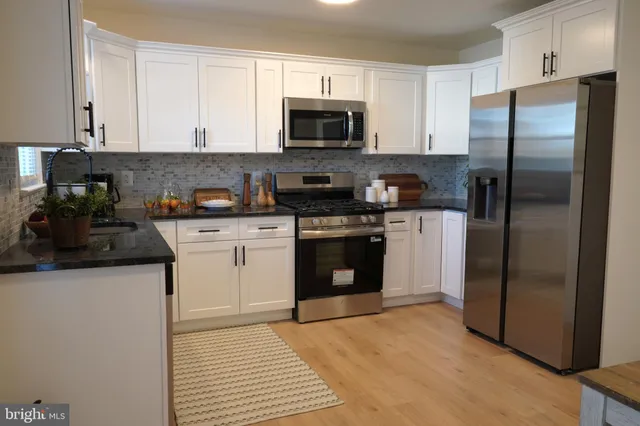 a kitchen with stainless steel appliances granite countertop a stove a refrigerator and a microwave