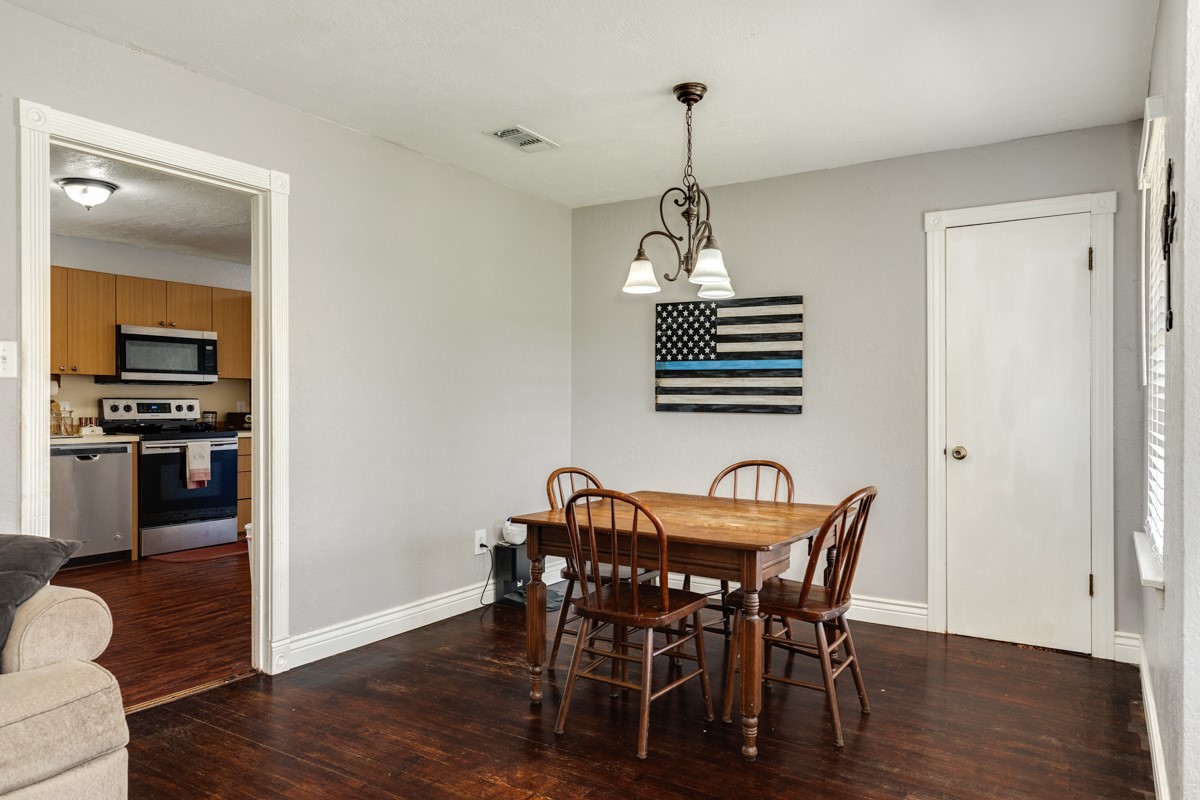 2109 North Tinsley Street Angleton, TX 77515 - Photo 13 of 27 a view of a dining room with furniture wooden floor and chandelier