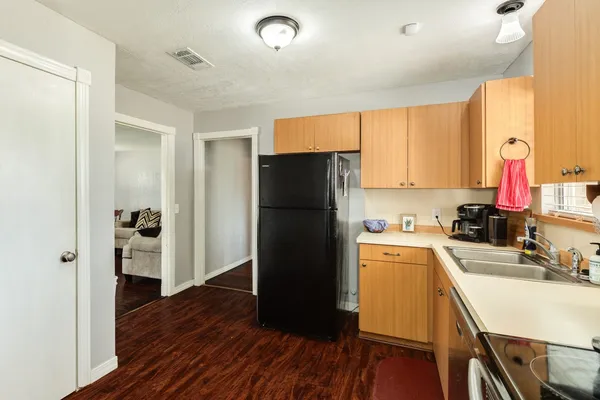a kitchen with a refrigerator and a stove top oven