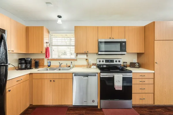 a kitchen with stainless steel appliances a stove a sink and a microwave
