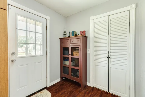 a view of a bedroom with wooden floor closet and windows