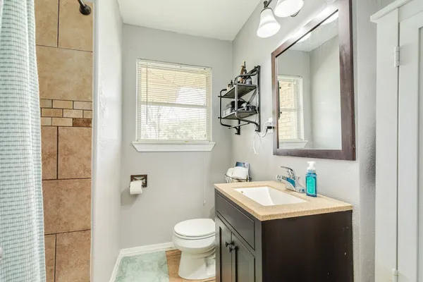 a bathroom with a sink toilet and mirror