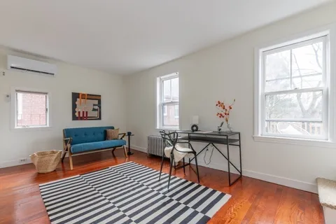 a living room with furniture a window and wooden floor