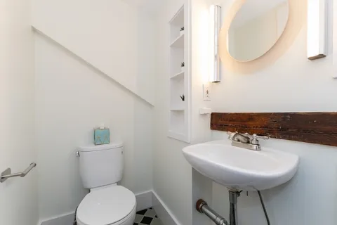 a bathroom with a sink a mirror and a toilet