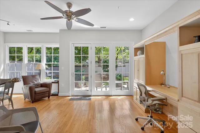 a living room with furniture floor to ceiling window and wooden floor