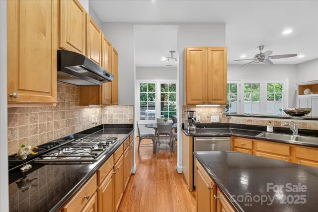 a kitchen with stainless steel appliances granite countertop a stove and a sink