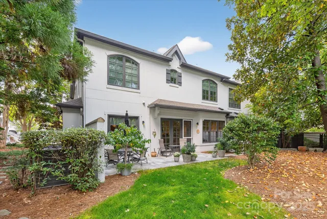 a view of a patio with table and chairs potted plants and large tree