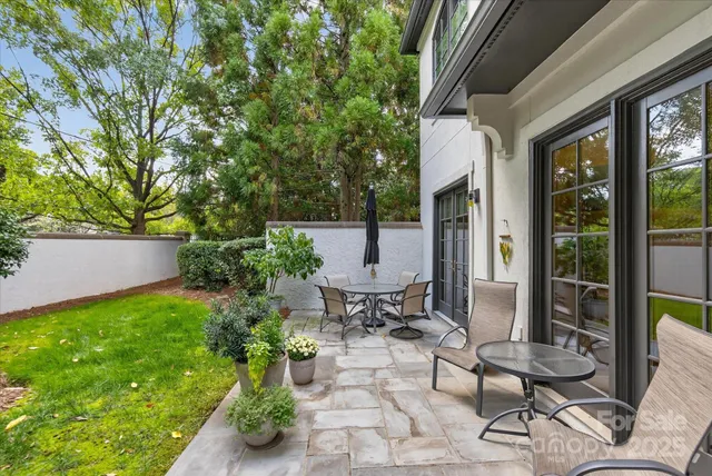 a view of a patio with chair and tables back yard of the house