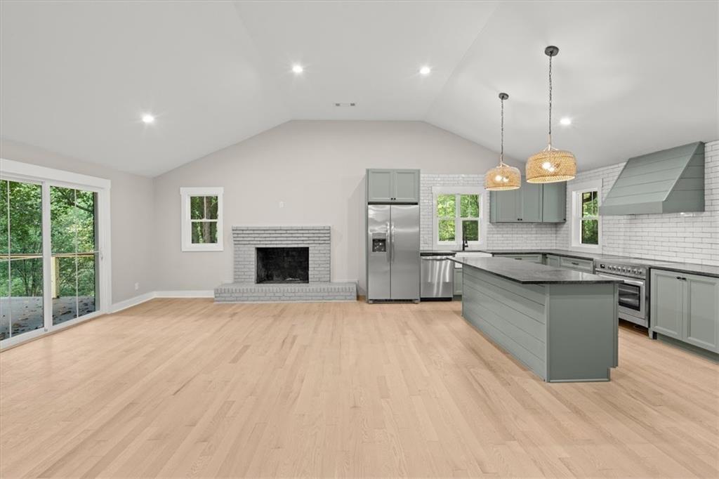 2237 Clem Lowell Road Carrollton, GA 30116 - Photo 11 of 60 a kitchen with stainless steel appliances granite countertop a sink a stove and a wooden floors